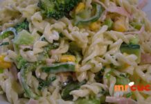 Receita de Macarronese Deliciosa: Como Preparar uma Opção Prática Macarronese: uma tigela colorida com macarrão, cenouras, milho, pimentões e cebola, cobertos por uma mistura cremosa de maionese e creme de leite.